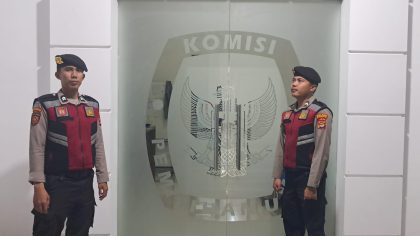two men in uniform standing in front of a glass door